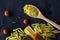 Different types of Italian pasta with a wooden spoon on a table with copy space