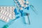 Different types of medication, tablets, capsules, ampoules and syringes on blue background