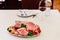 Different types of raw beef with fresh herbs and vegetables on the table for customer selection