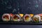 Different types of rolls stand on a black granite board for sushi on a black background