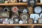 Different types of watches on the shelf. An old wall clock. Dusty dials in the watchmaker`s workshop.