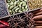 Different types of whole Indian spices in wooden box close-up top view