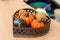 Different varieties of decorative artificial pumpkins in a wicker bowl on a wooden farmer`s counter. Vegetable Harvest Festival,