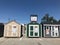 Different varieties of sheds on display in a parking lot of a chain hardware store