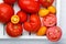 Different varieties of tomatoes on a white tray. Colorful red and yellow fresh ripe tomatoes. Top view