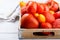 Different varieties of tomatoes on a wooden tray. Colorful red and yellow fresh ripe tomatoes