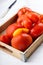 Different varieties of tomatoes on a wooden tray. Colorful red and yellow fresh ripe tomatoes
