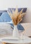 Diffuser and  bouquet of  plants in  vase in  bedroom in  sunlight