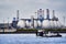 Digesters of a sewage treatment plant of the Hamburg waterworks on the Elbe with a ferry in the foreground on the river