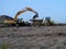 Digger and dumper truck working on waste ground reclamation