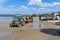 Digger on trailer behind tractor on beach