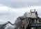 Digger working on a demolition site destroying a section of wall creating dust and rubble