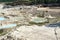 Digging excavator on a quarry with kaolin clay, light sand and blue water, beautiful landscape, industrial excavation of useful