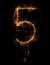 Digit 5 or five made of bengal fire, sparkler fireworks candle isolated on a black background