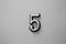 Digit five - number on gray background black white image.