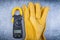 Digital ammeter safety gloves on metallic background