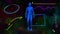 Digital animation of human body model walking against abstract shapes and particles in background