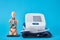 Digital blood pressure monitor and anatomical human model on a blue background, closeup. Helathcare and medicine concept
