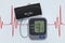 Digital Blood Pressure Monitor with Cuff on Cardiogram Backgrou