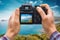Digital camera in hands shooting seascape, photographer POV.