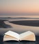 Digital composite of Beautiful colorful vibrant sunrise over low tide beach landscape peaceful scene in pages of open book