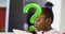 Digital composite of green question mark over confused schoolgirl reading book in classroom