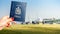 Digital composite of holding a Canadian passport with a row of commercial airplanes on taxiing on tarmac