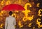 Digital composite image of businesswoman holding red umbrella looking at burning symbol of pounds