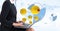 Digital composite image of emojis flying by businesswoman using laptop against tech graphics in back