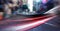 Digital composite image of red digital waves and spot of light against view of city traffic