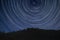 Digital composite image of star trails around Polaris with Pine tree ridge landscape in Snowdonia