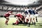 Digital composite image of team of rugby players tackling each other to win the ball in sports stadi