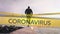 Digital composite video of yellow police tapes with Warning Quarantine Coronavirus text against man