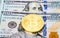 Digital cryptocurrency coin gold bitcoin lying over american dollar bills