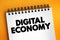 Digital economy is an economy that is based on digital computing technologies, text concept on notepad