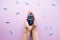 Digital glucometer in the hands of a woman on a pink background, flat lay. Diabetes concept