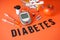 Digital glucometer, lancet pen, syringes, shopping cart with diabetes accessories and fruits on a red background. Diabetes concept