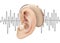 Digital hearing aid behind the ear, on the background of sound wave diagram. Treatment and prosthetics of hearing loss