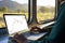 Digital nomad work inside the train and view of landscape through windows.