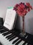 Digital Piano with Music Sheet and Vase of Flowers