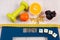 Digital scale with tape measure, dumbbells, tablets, fruits, slimming concept