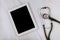 Digital tablet computer with medical stethoscope on marble table on the medical office hospital