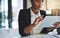 Digitizing her work to do list. a young businesswoman using a digital tablet in a modern office.