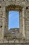 Dilapidated ancient synagogue. View of the sky and the wall through the arched window. The texture of old dilapidated masonry.