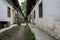 Dilapidated dwelling buildings along unpaved alley