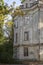 Dilapidated facade of an old building in an autumn park