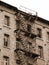 dilapidated industrial building with rusty fire escape with faci