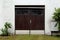 Dilapidated old garage doors made from narrow vertical boards protected with sheet metal at bottom with broken windows covered