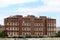 Dilapidated old seven story apartment building surrounded with construction site in front and other buildings in back