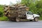 Dilapidated pickup truck carrying logs in thailand